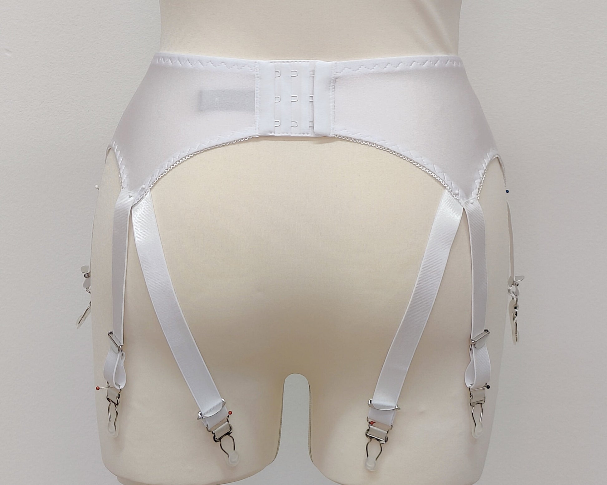 A white Nina garter belt with additional straps attached to the back