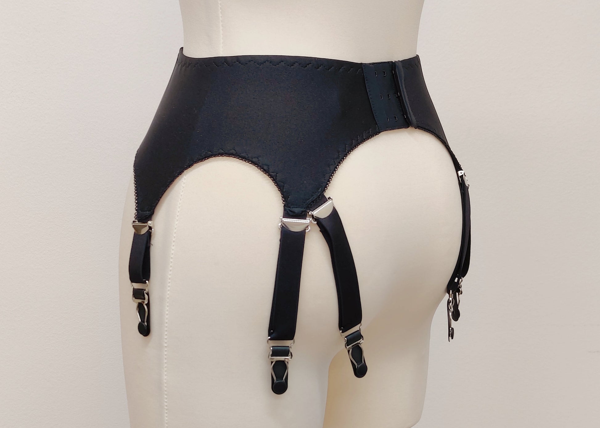 A black Nina garter belt with additional straps attached to the back, side view