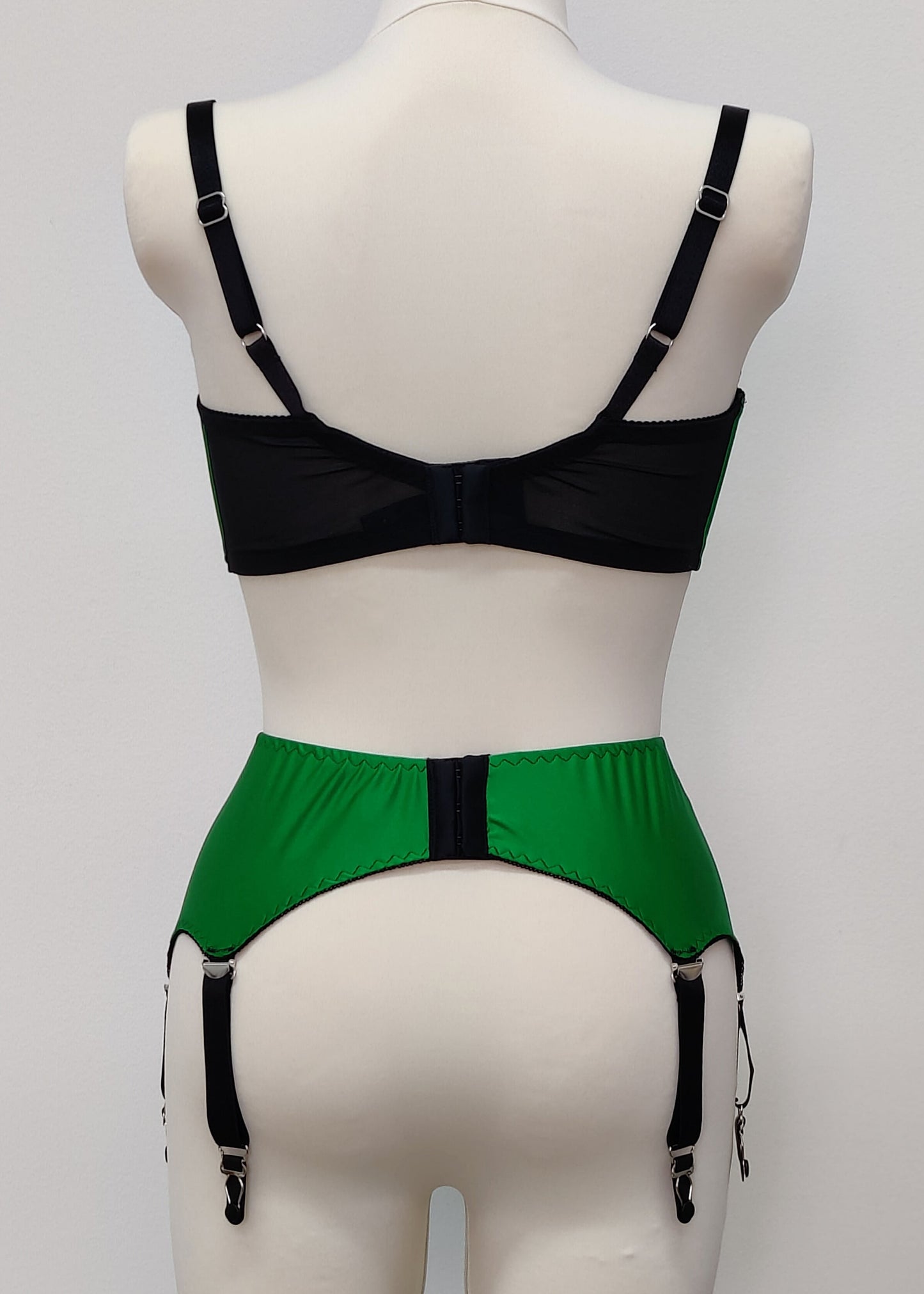 emerald green open quarter cup Gina bra with black straps and trim, shown with matching Greta garter belt, back view