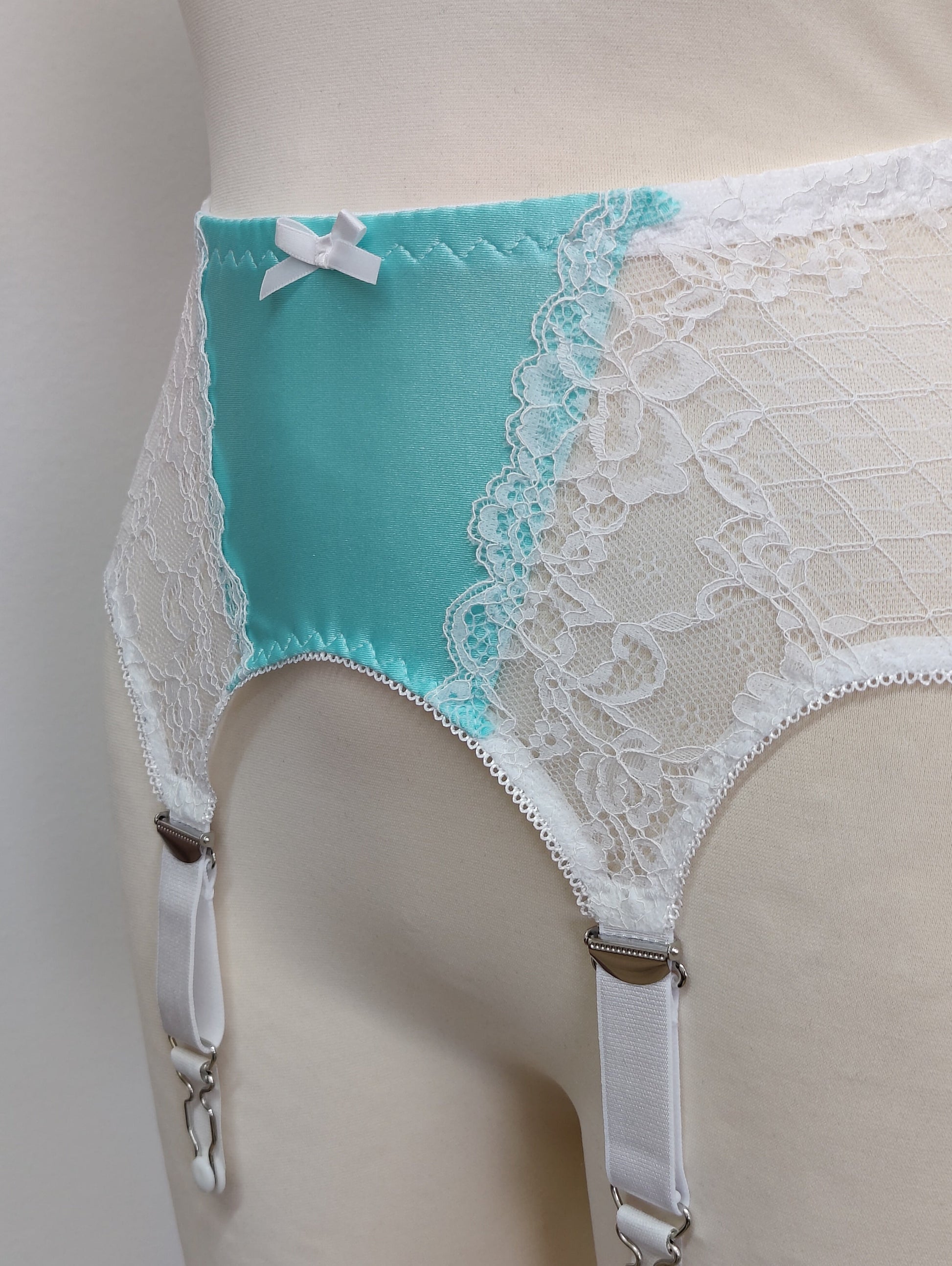 A white lace and Aqua blue Lycra, Mona garter belt with 6 adjustable straps and hook and eye closure, detail