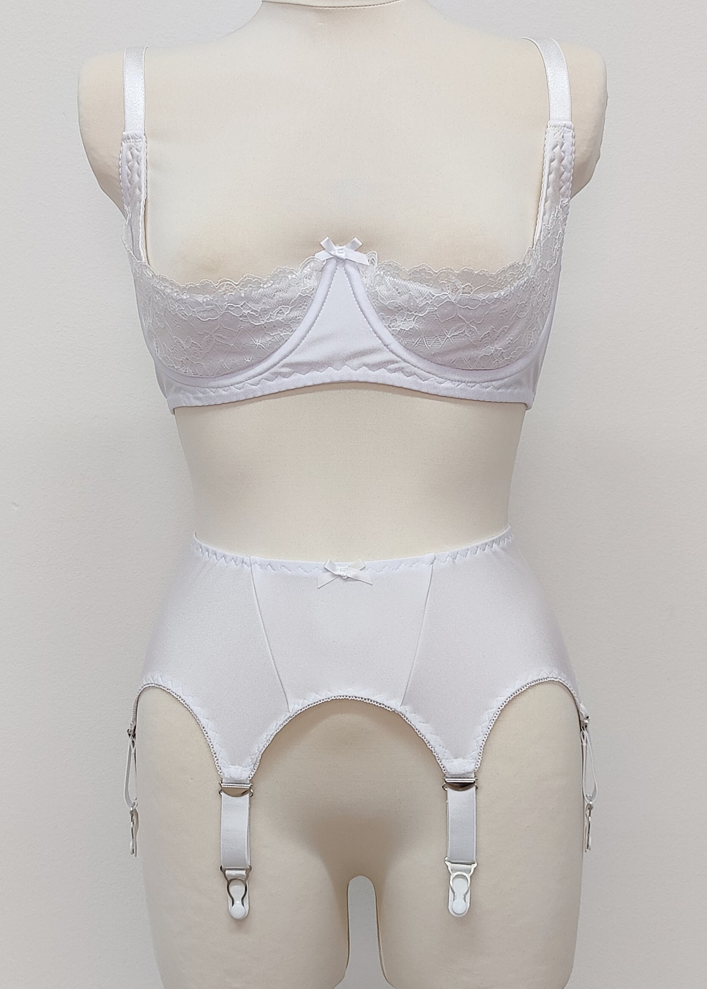 White narrow Nina garter belt, 60's style with 6 adjustable straps and hook and eye closure at the back. Shown with Lucy quarter cup bra.