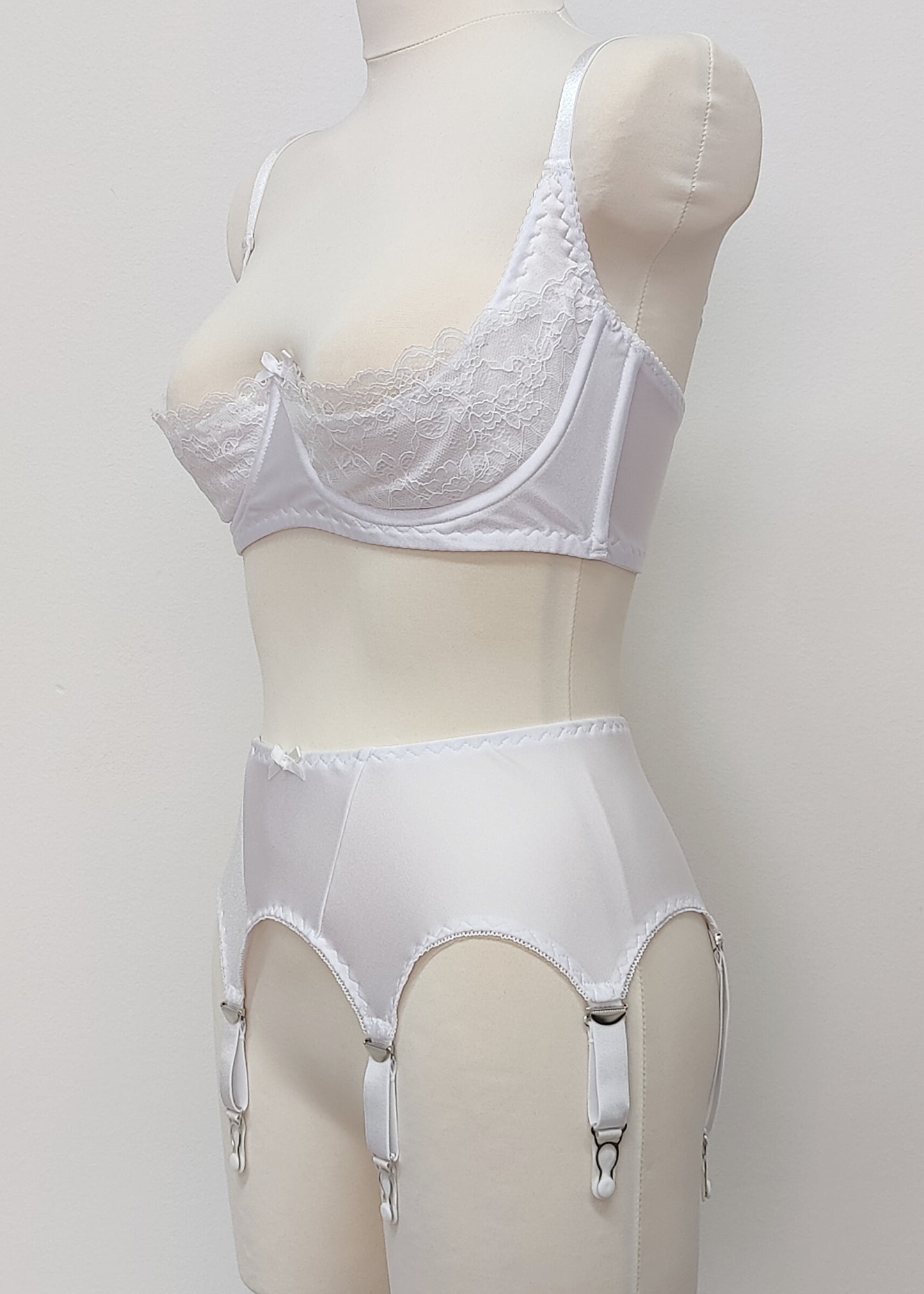 White narrow Nina garter belt, 60's style with 6 adjustable straps and hook and eye closure at the back. Shown with Lucy quarter cup bra. Side view