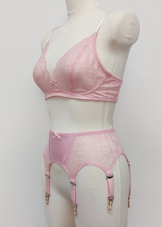 Pink lace Mona garter belt with 6 adjustable straps and hook and eye closure, displayed on a mannequin with matching bralette, side view