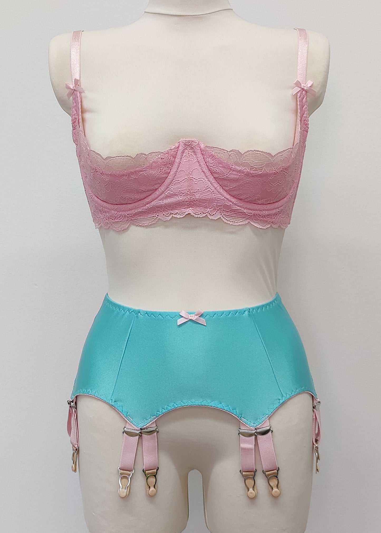 aqua blue 12 strap Joan garter belt with pink straps shown with pink Lucrezia quarter cup bra