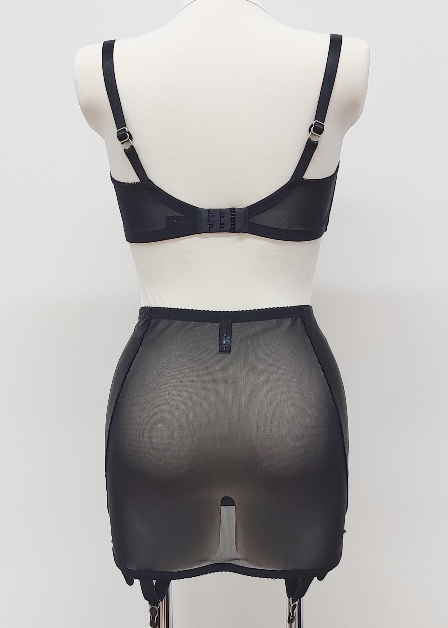 black 6 strap Rhonda open bottom girdle, with sheer back and silvery lace trim on the front, shown with black Gina quarter cup bra, back view