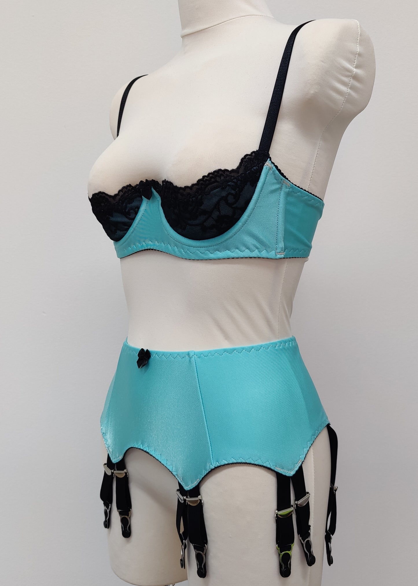 baby blue 12 strap Joan garter belt with black straps, shown with matching Lucy quarter cup bra, side view