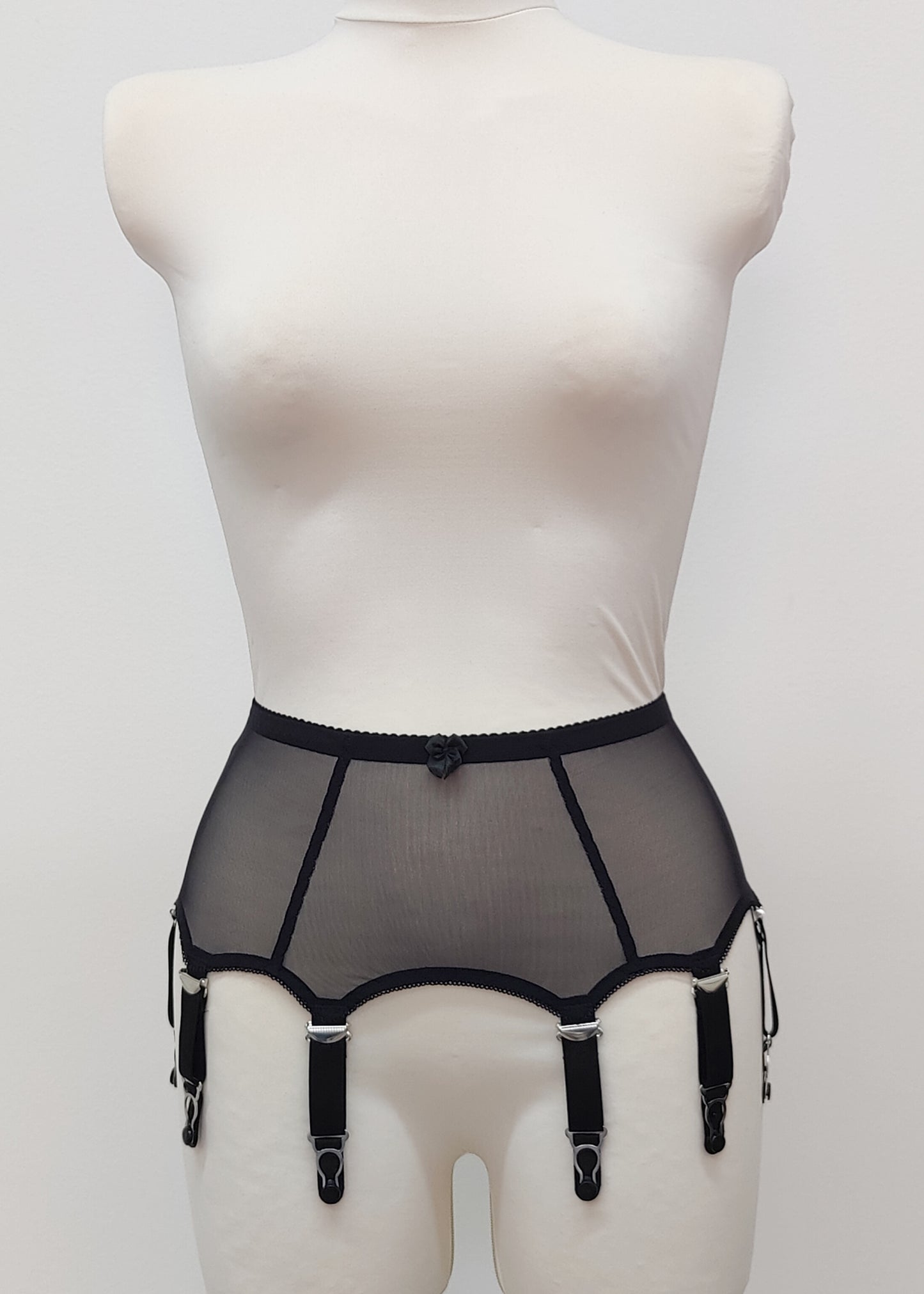 Black sheer 8 strap garter belt on a mannequin against a white background