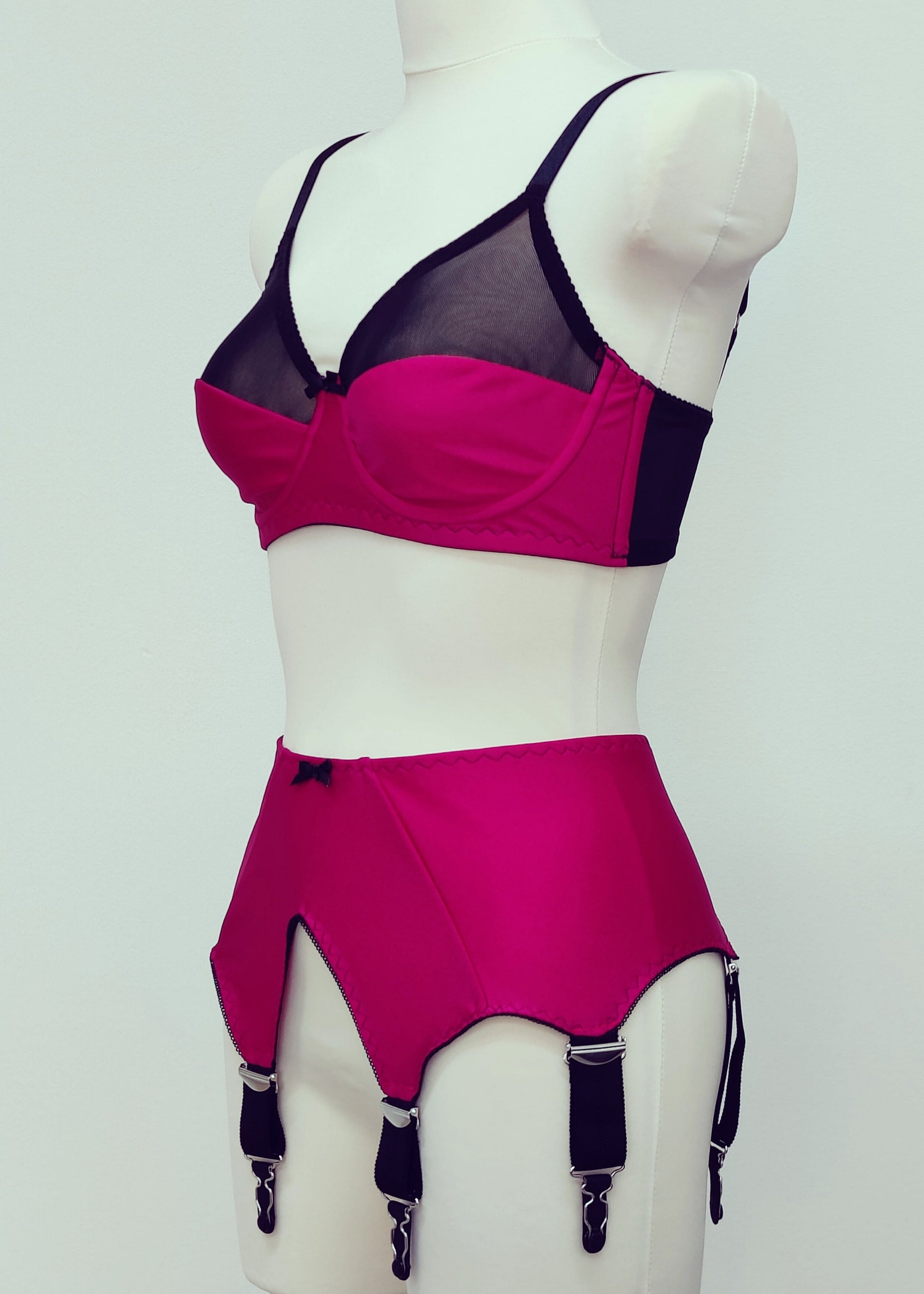 magenta pink wide vintage style Iris garter belt, with black trim and 6 extra wide black straps, here shown with matching Audrey full cup bra, side view