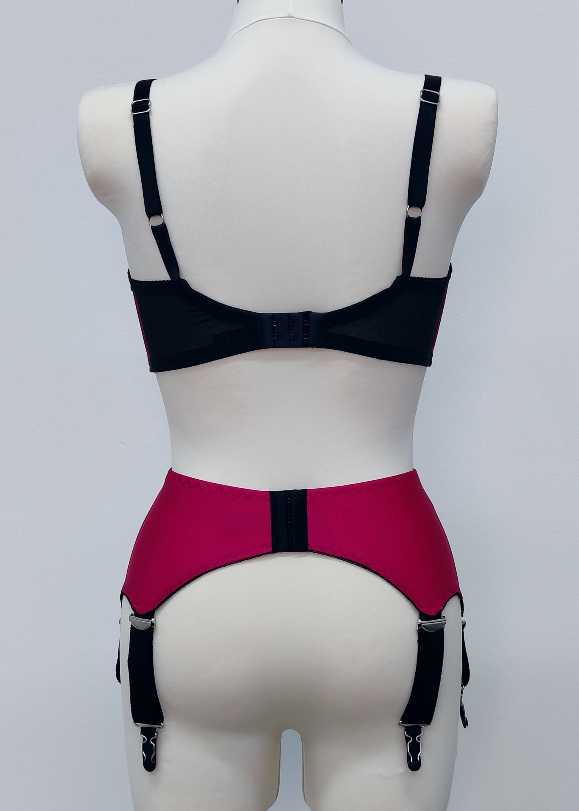 magenta pink wide vintage style Iris garter belt, with black trim and 6 extra wide black straps, here shown with matching Audrey full cup bra, back view