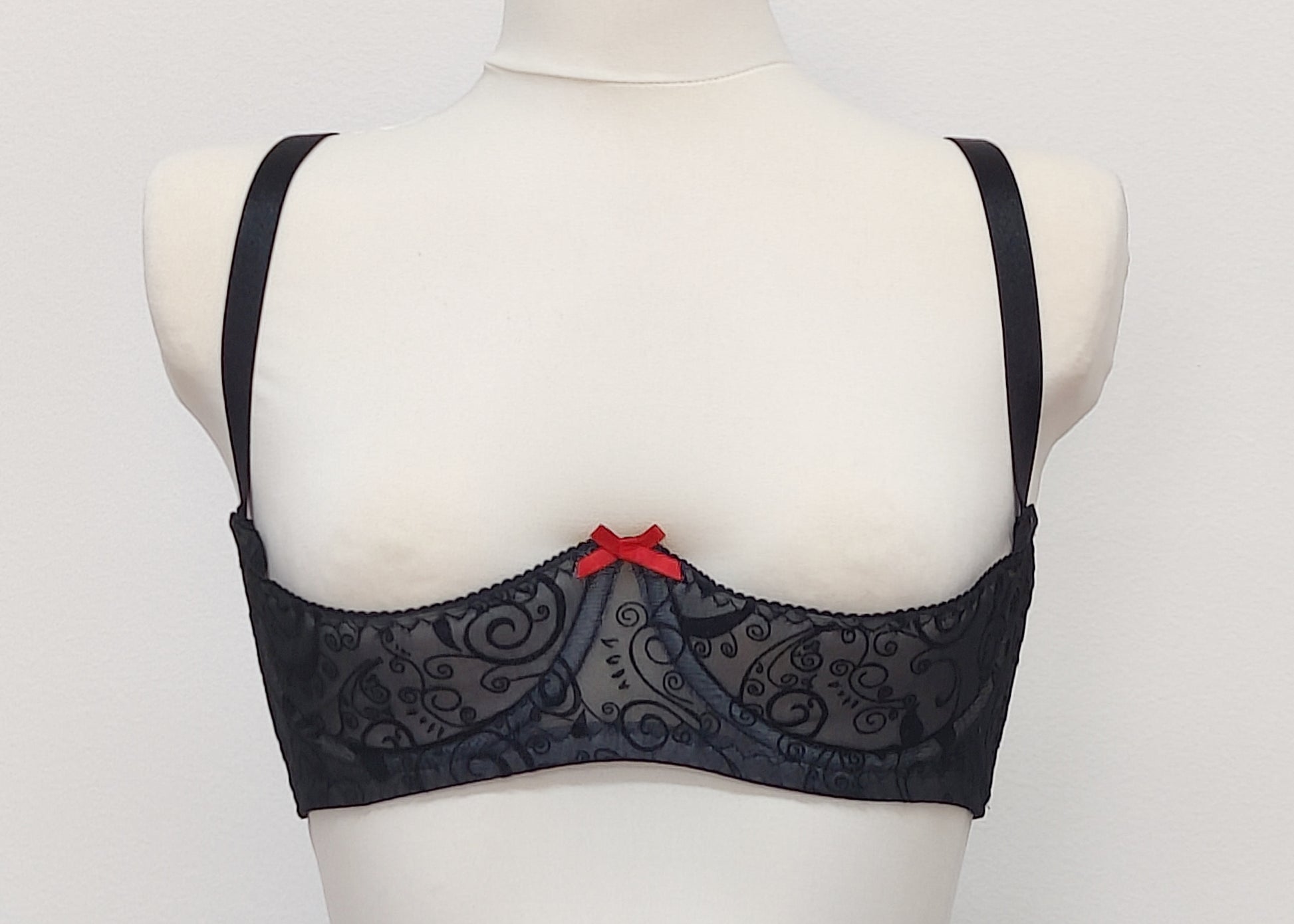 black swirl patterned mesh, quarter cup bra with red bow