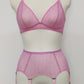 Pink sheer LULA garter belt with 6 adjustable straps displayed on a mannequin. The belt has a transparent mesh design with pink accents and metal hardware.