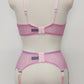 Pink sheer LULA garter belt with 6 adjustable straps displayed on a mannequin. The belt has a transparent mesh design with pink accents and metal hardware. back view