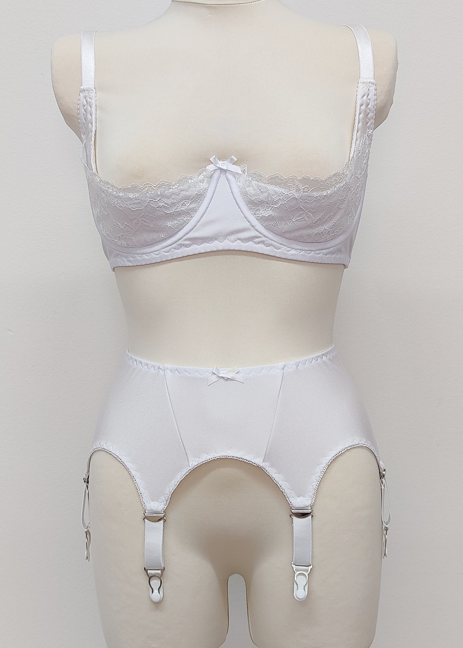 White narrow Nina garter belt, 60's style with 6 adjustable straps and hook and eye closure at the back. Shown with Lucy quarter cup bra.