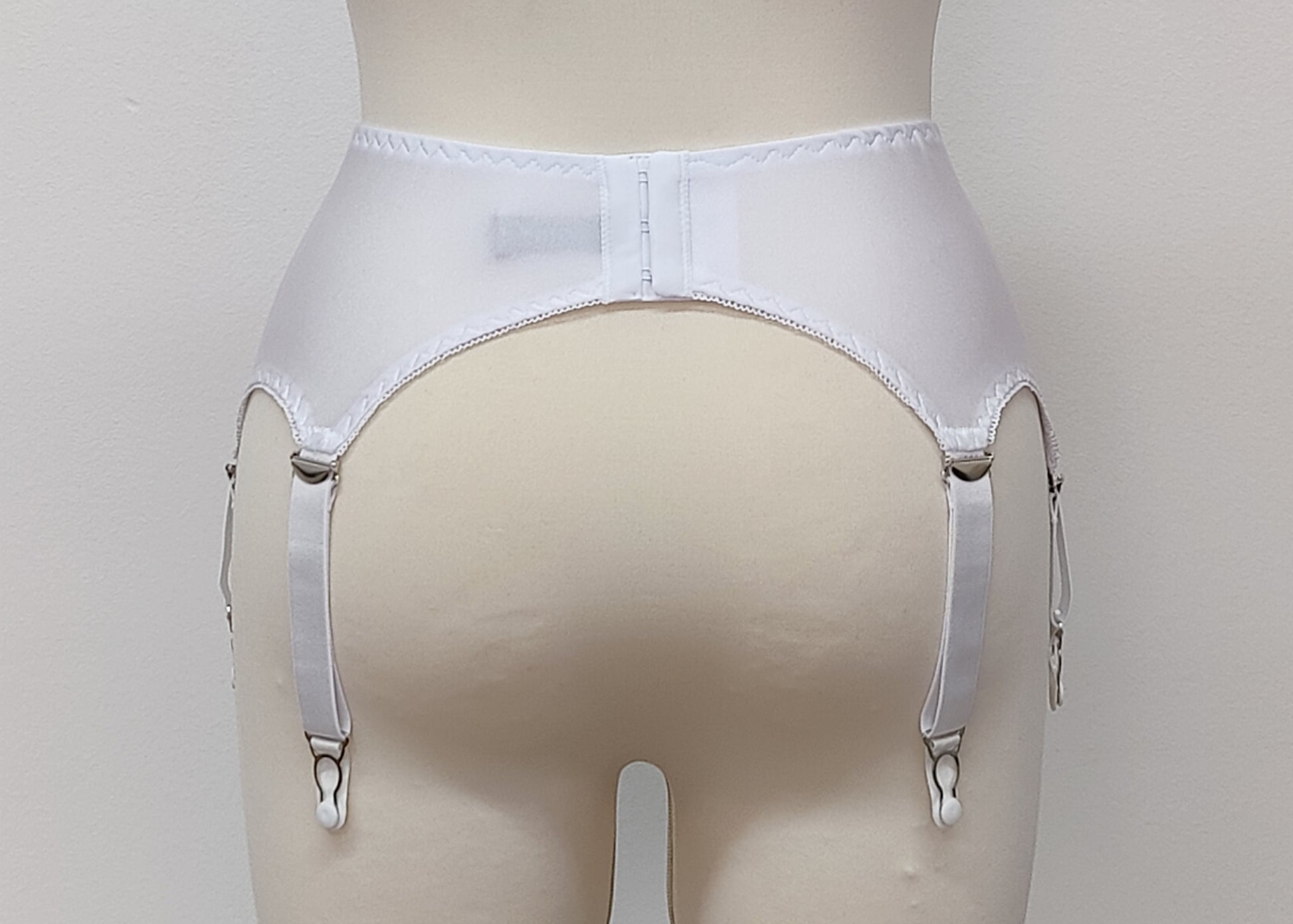 White narrow Nina garter belt, 60's style with 6 adjustable straps and hook and eye closure at the back. back view