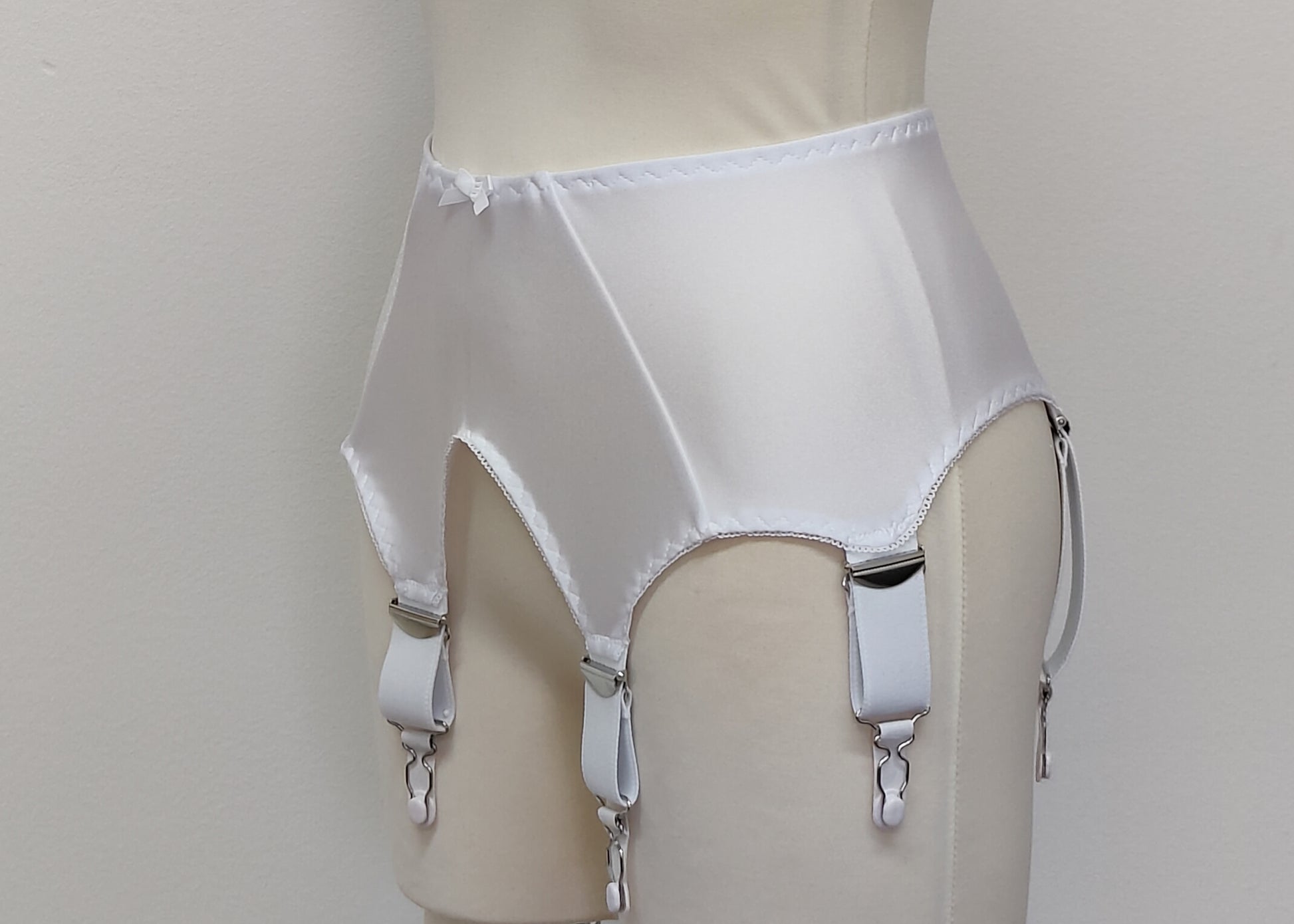 White wide Iris garter belt with a deep V-style design, featuring six extra wide adjustable straps, side view