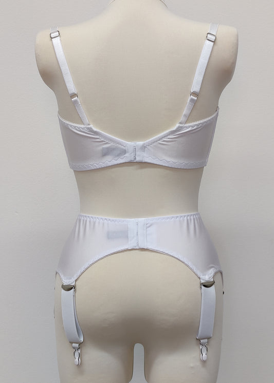 White wide Iris garter belt with a deep V-style design, featuring six extra wide adjustable straps, shown with matching white bra, back view