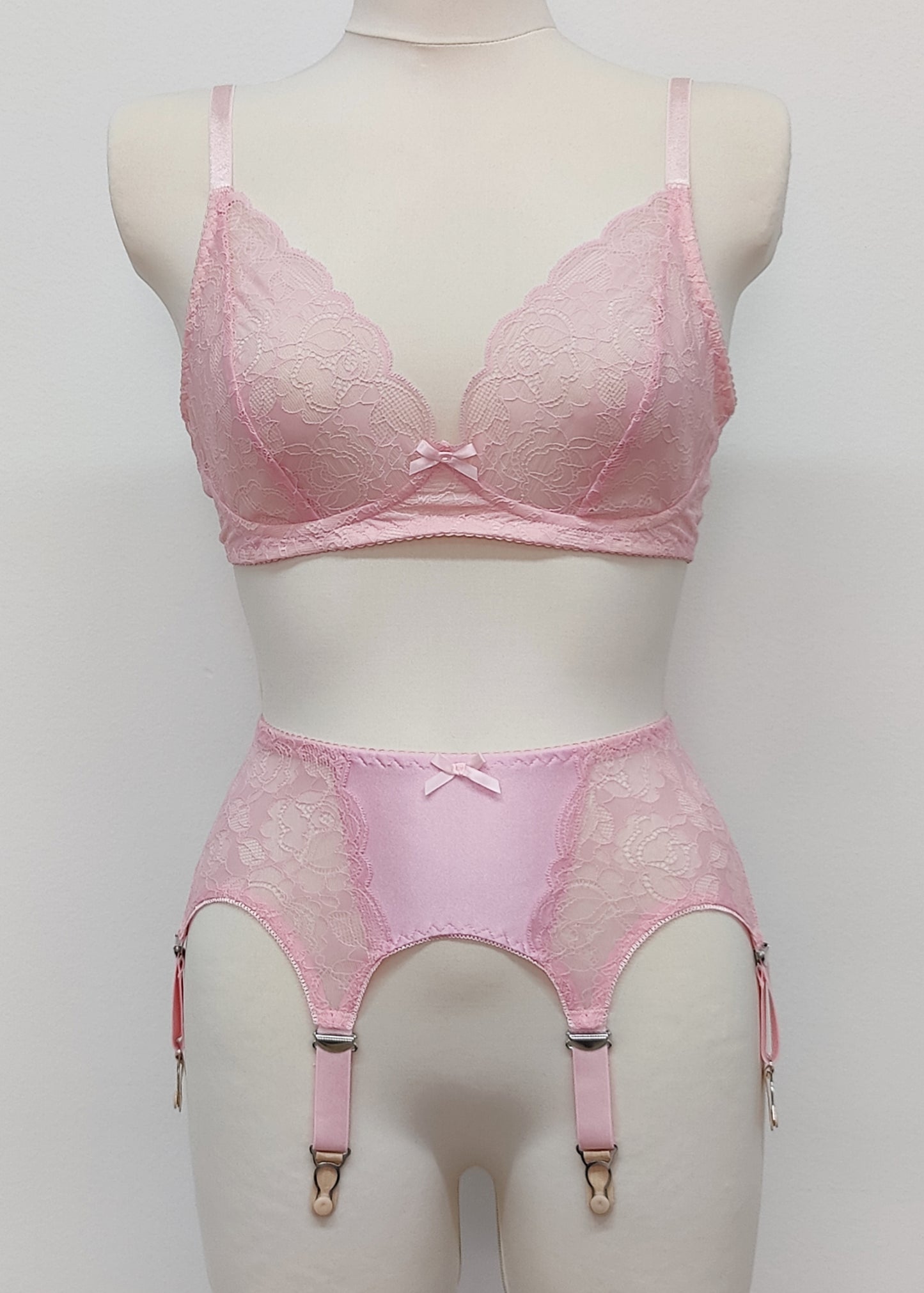 Pink lace  Mona garter belt with 6 adjustable straps and hook and eye closure, displayed on a mannequin with matching bralette