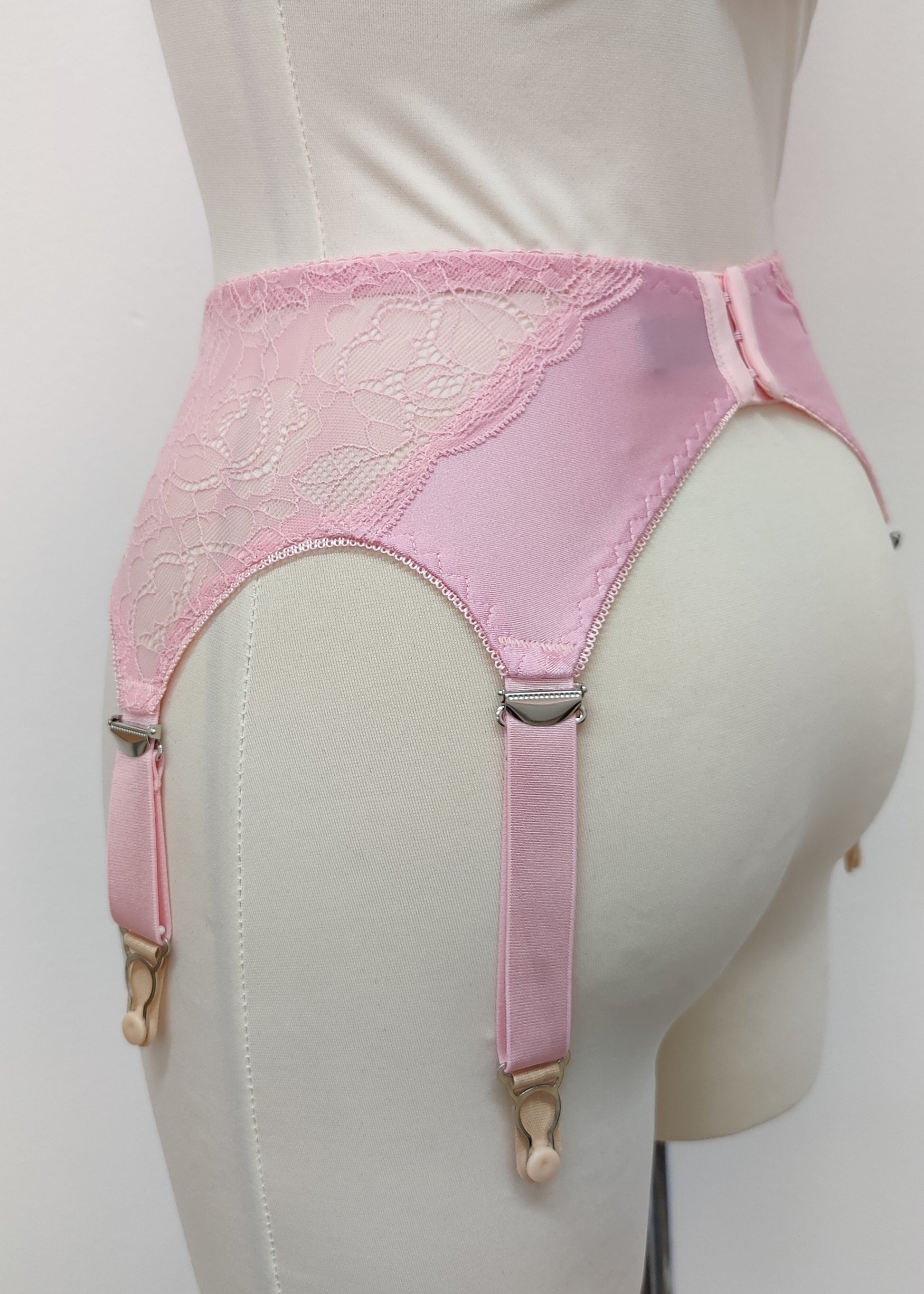 Pink lace  Mona garter belt with 6 adjustable straps and hook and eye closure, displayed on a mannequin,back view