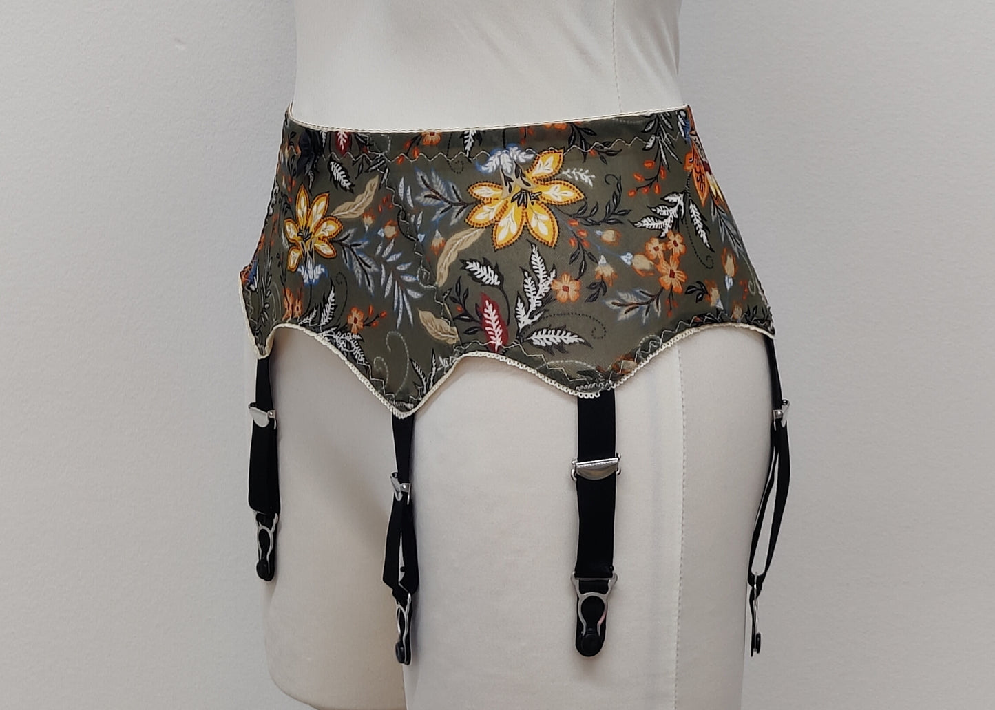 retro style Leilani suspender belt, made with olive green floral mesh fabric, with 6 wide straps, side view