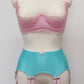 aqua blue 12 strap Joan garter belt with pink straps shown with pink Lucrezia quarter cup bra