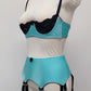 baby blue 12 strap Joan garter belt with black straps, shown with matching Lucy quarter cup bra, side view