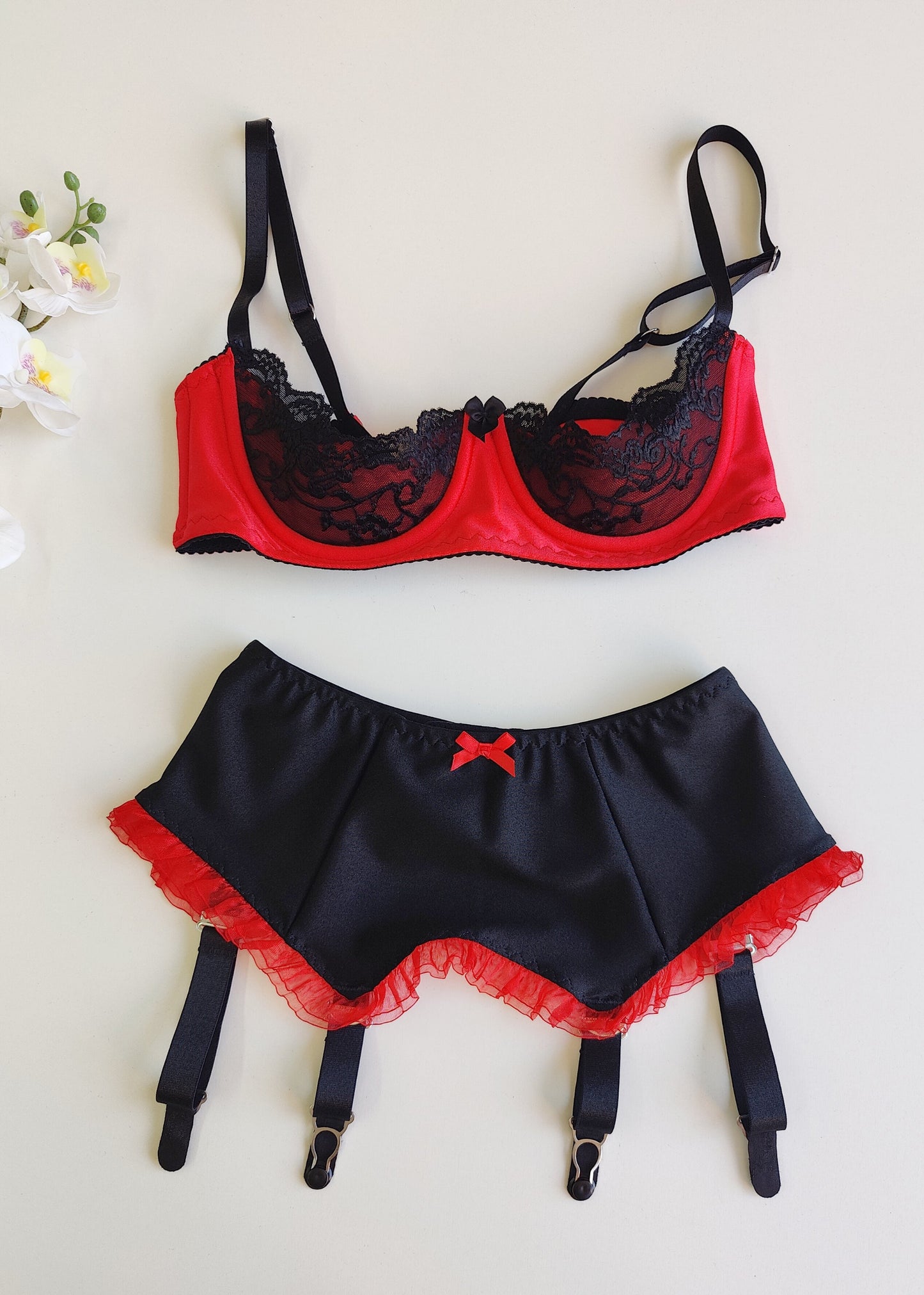 black 4 strap Gigi garter belt with red ruffle trim and bow, shown with red/black Lucy bra
