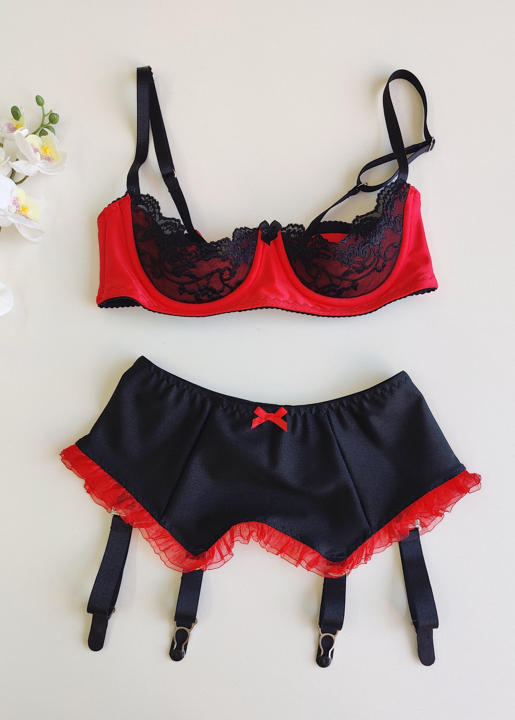 black 4 strap Gigi garter belt with red ruffle trim and bow, shown with red/black Lucy bra