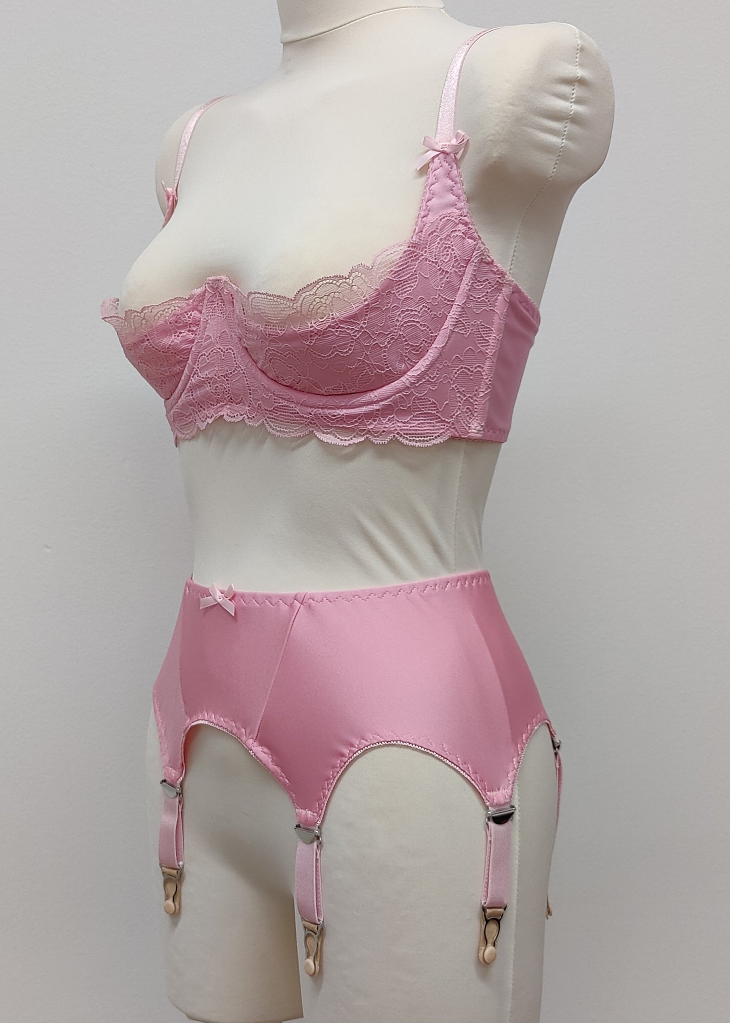 Pink narrow Nina garter belt, 60's style with 6 adjustable straps and hook and eye closure at the back. Shown with matching Lucrezia quarter cup bra, side view