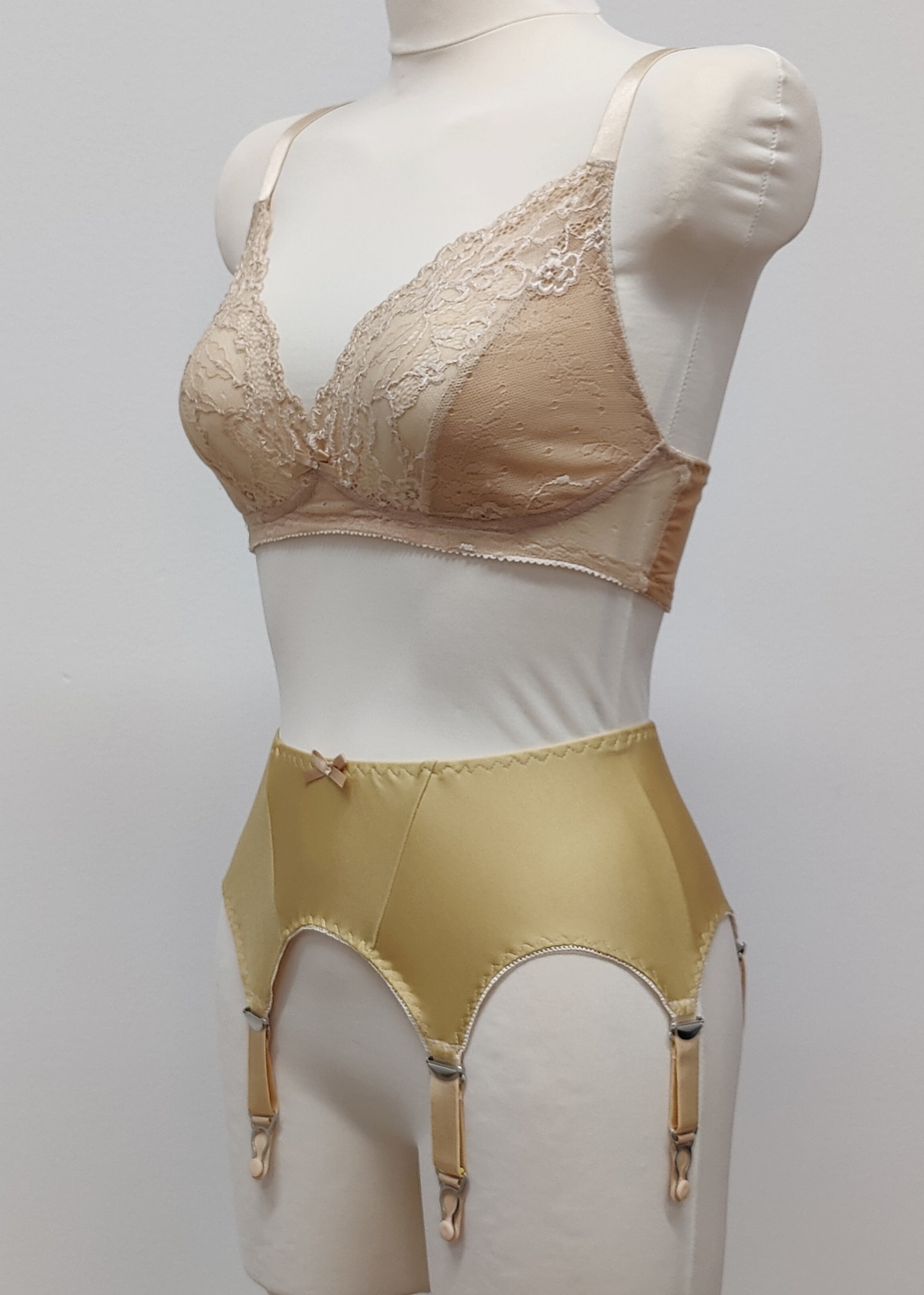 Beige narrow Nina garter belt, 60's style with 6 adjustable straps and hook and eye closure at the back. Shown with matching  bra, side view