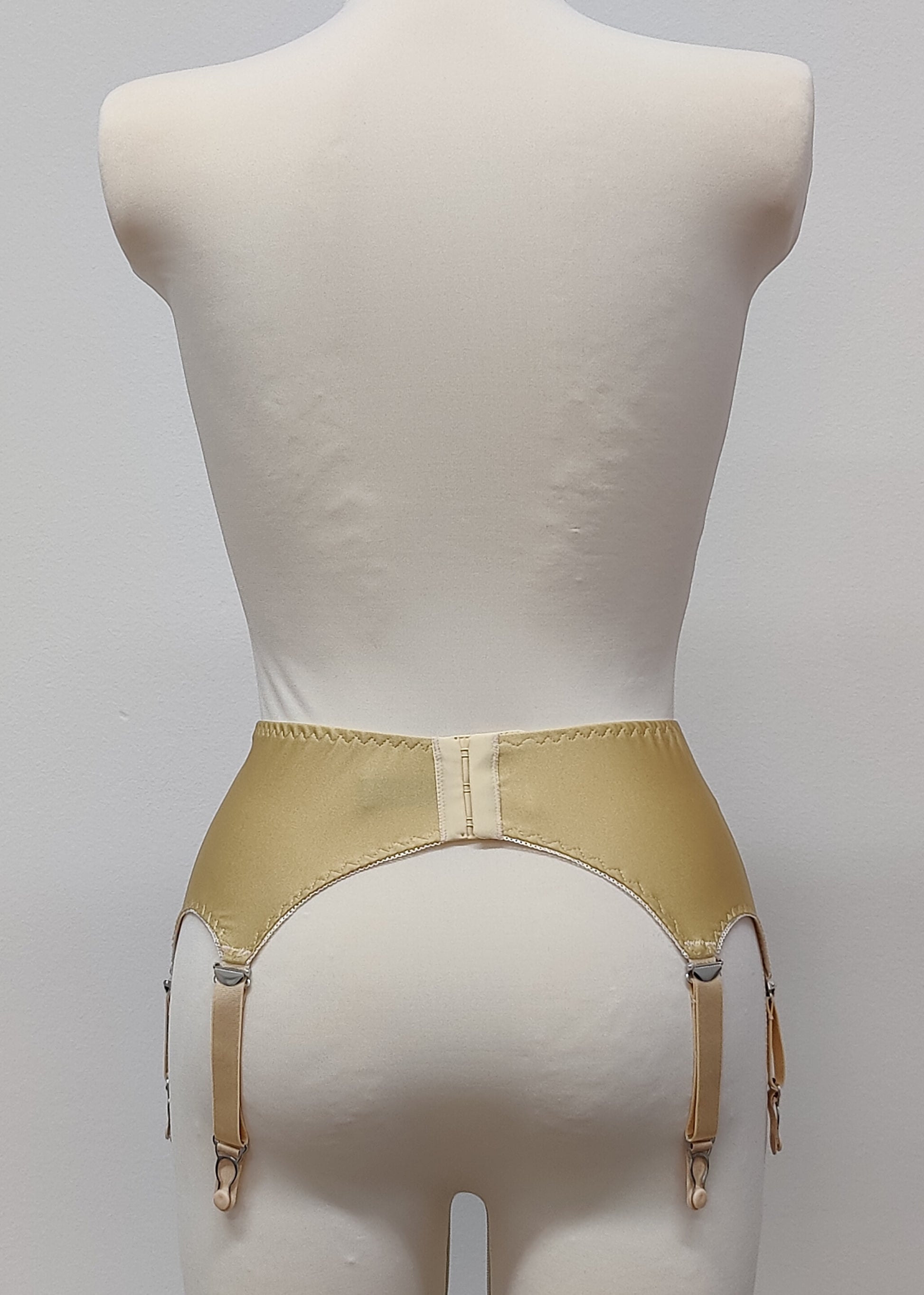 Beige narrow Nina garter belt, 60's style with 6 adjustable straps and hook and eye closure at the back, back view
