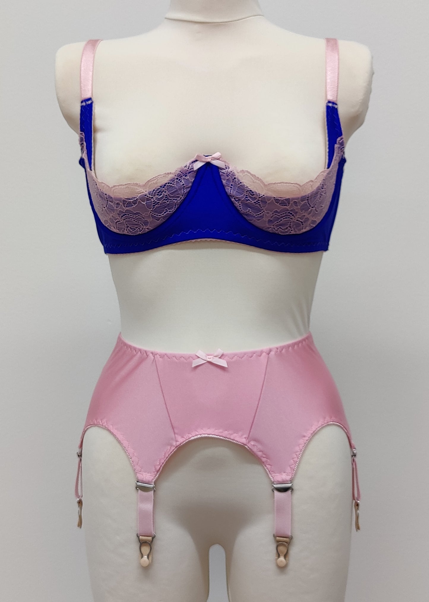 Quarter cup Lucy bra, here shown in blue with pink lace, straps and trims. On the photo is also Nina 6 strap garter belt in pink. 