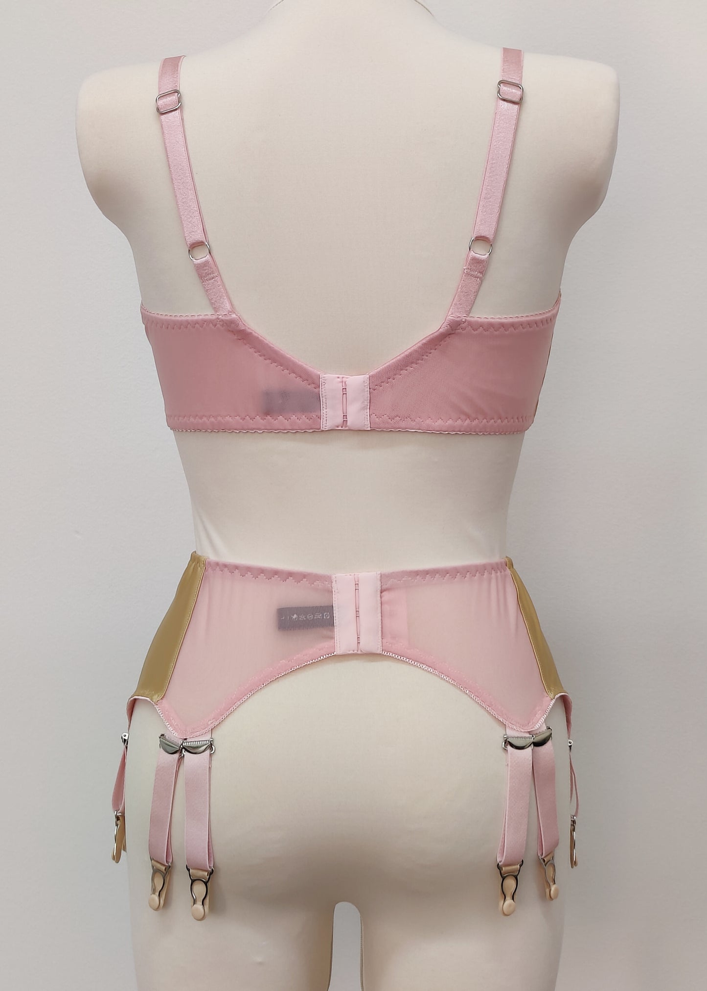 beige Audrey bra with pink sheer upper part of the cup,straps and trim, here shown with matching Stella garter belt, back view