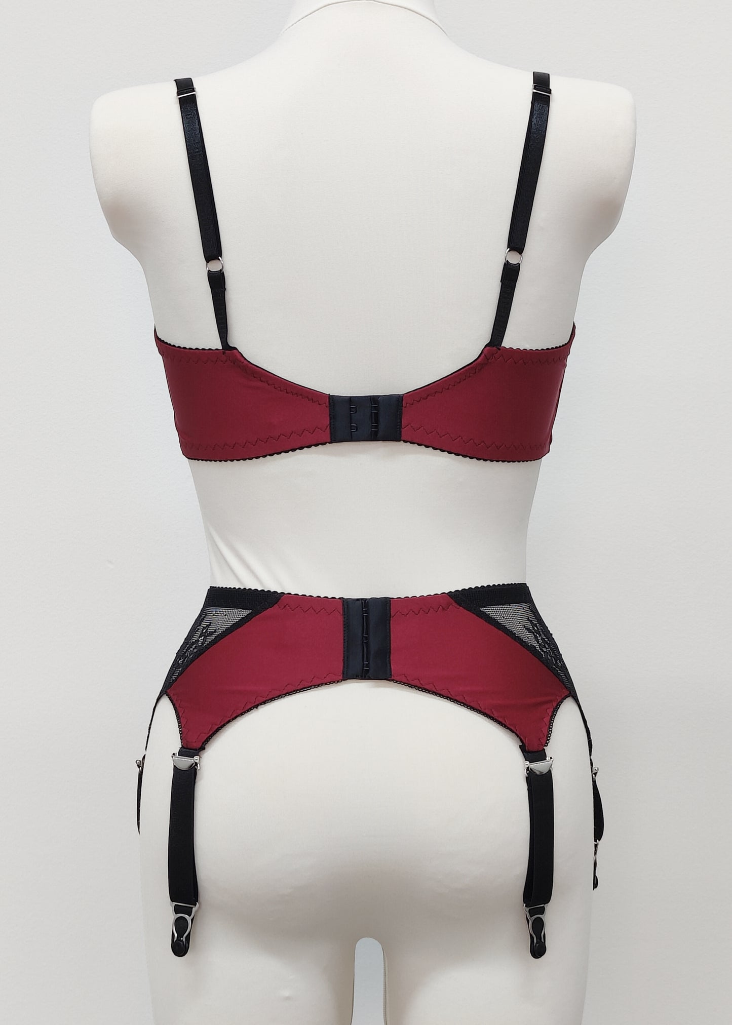 High waist Mona garter belt in maroon color with black lace side panels and 6 adjustable straps, here shown with matching Lucy quarter cup, back view