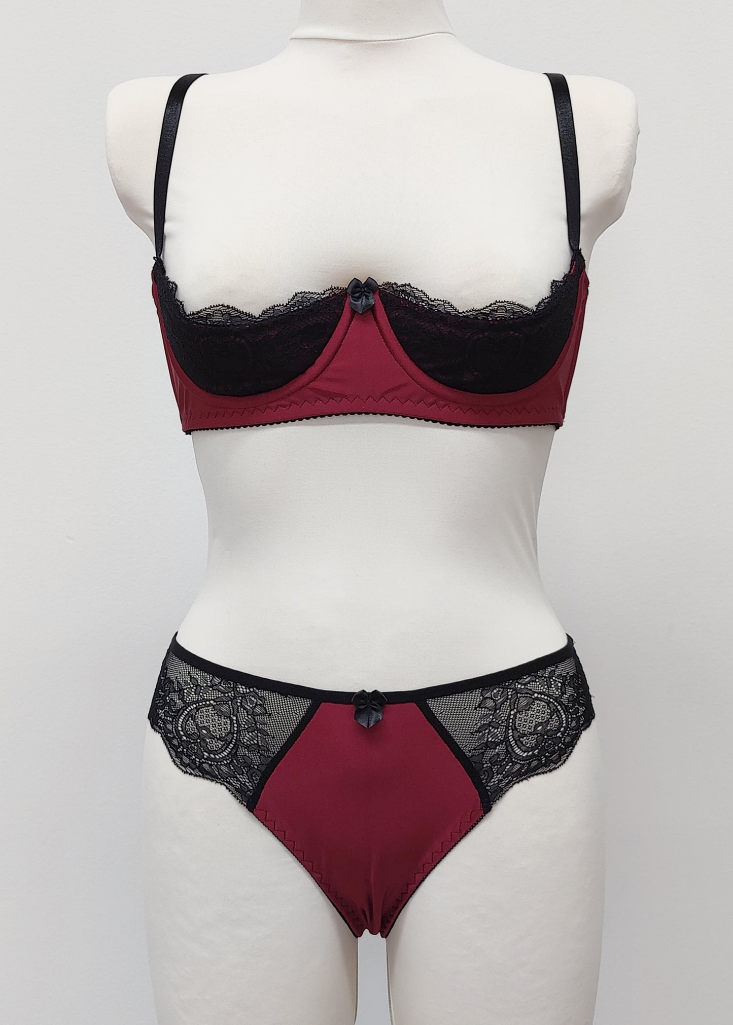 Maroon Red and black lace lingerie set on a mannequin against a white background. Zigi tanga with lace on the back and side panels and Lucy quarter cup bra