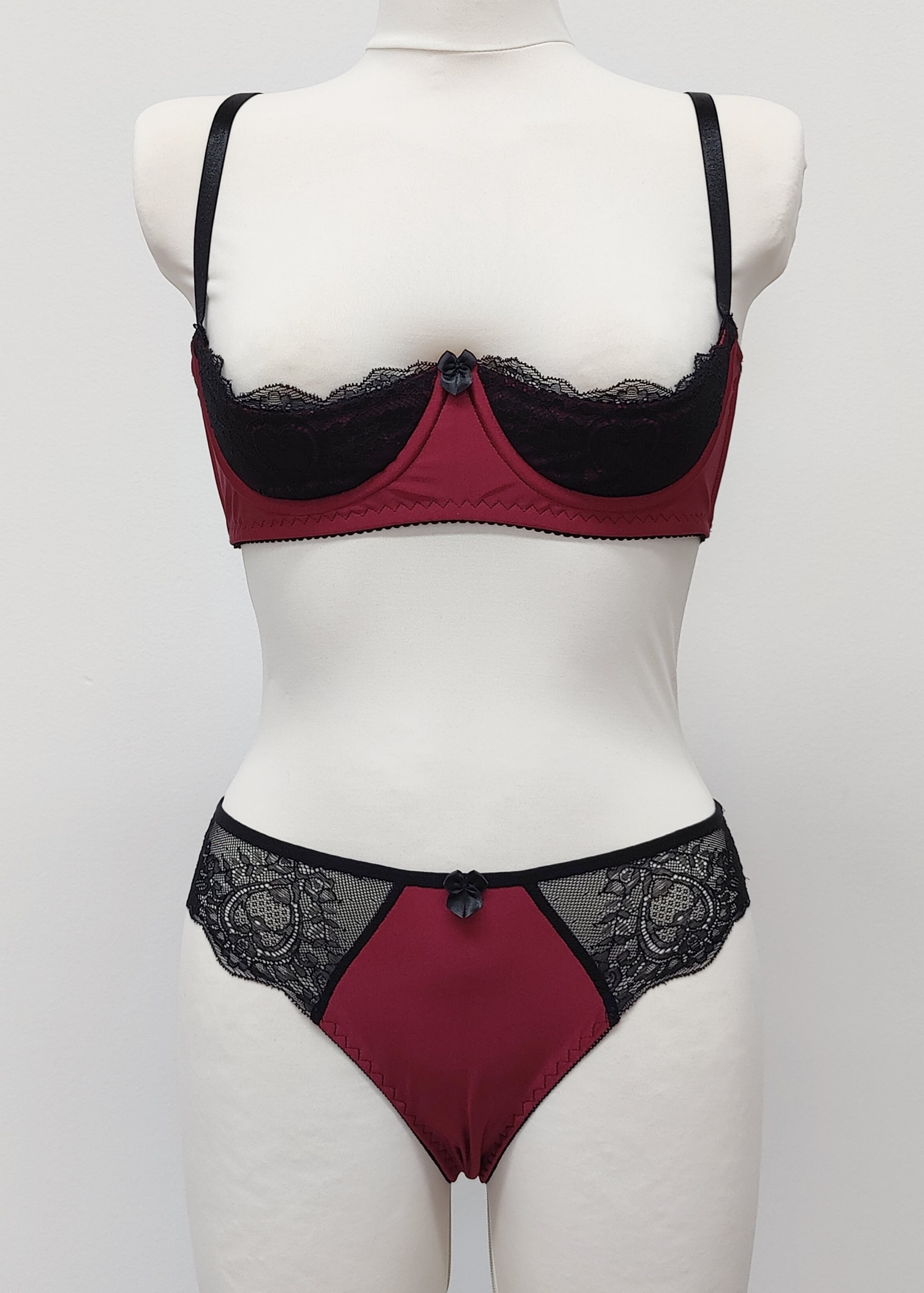 Maroon Red and black lace lingerie set on a mannequin against a white background. Zigi tanga with lace on the back and side panels and Lucy quarter cup bra