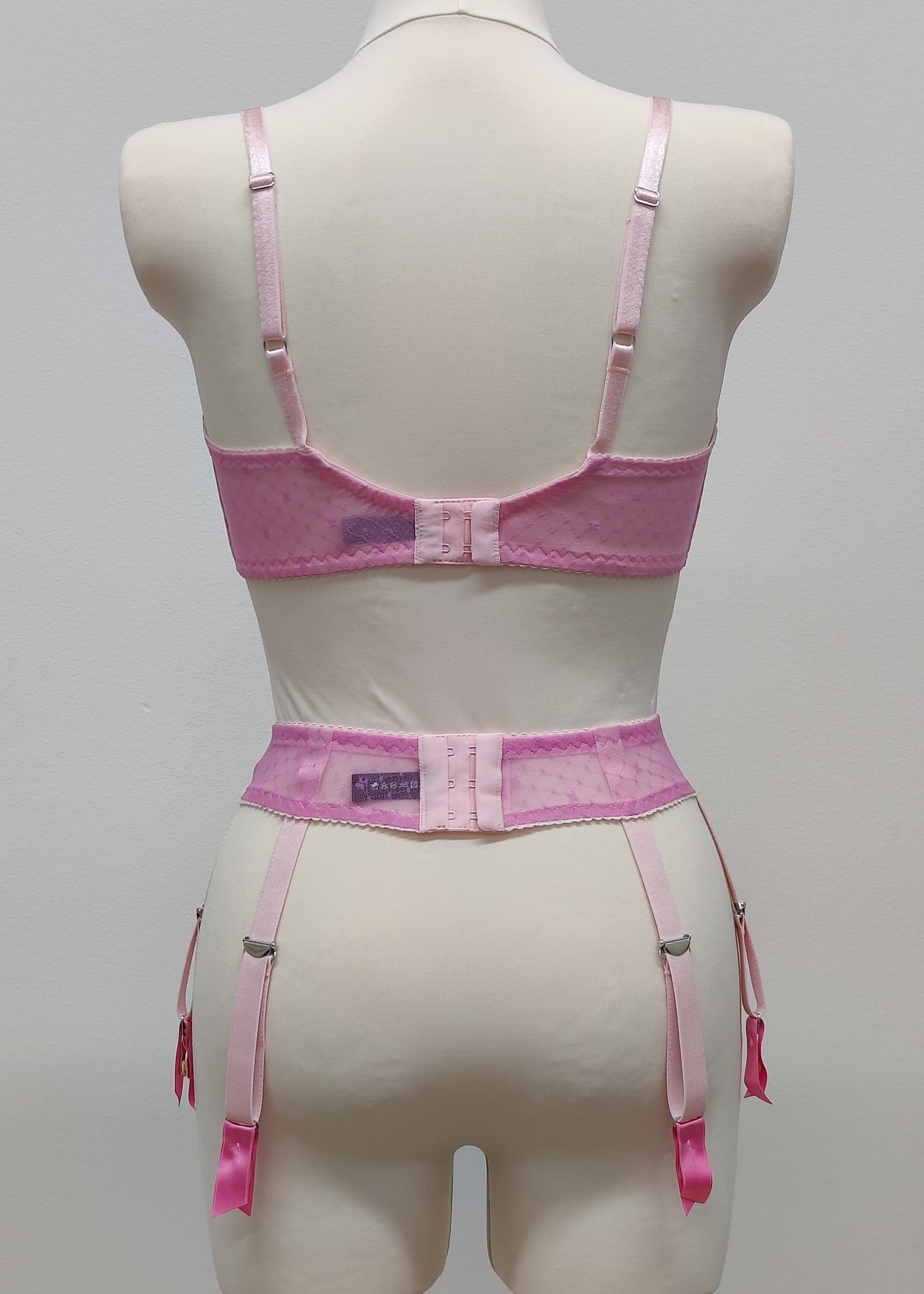 Full cup Lily bra made with fuchsia pink-star mesh fabric, here presented with matching customized Summer suspender belt, back view