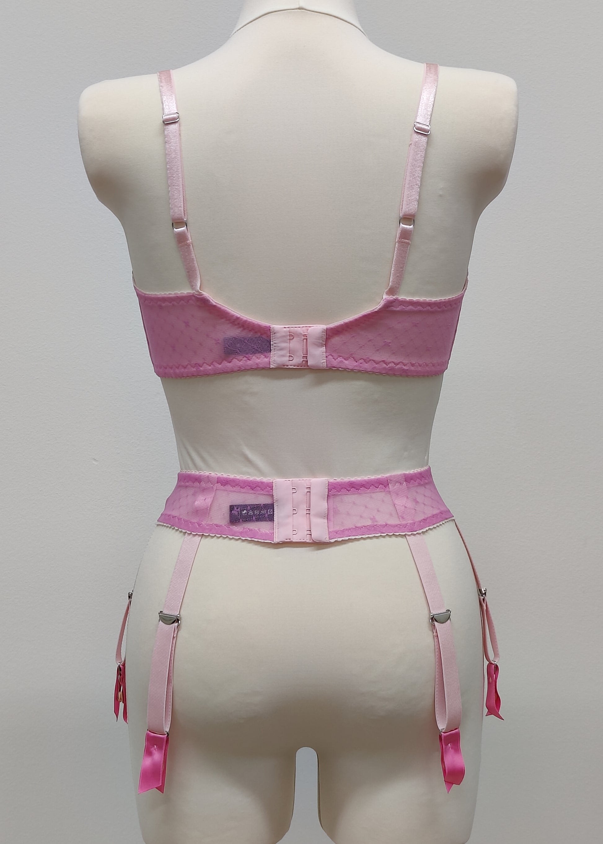 Full cup Lily bra made with fuchsia pink-star mesh fabric, here presented with matching customized Summer suspender belt, back view