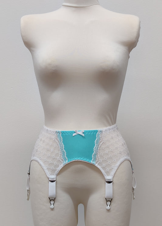 A white lace and Aqua blue Lycra, Mona garter belt with 6 adjustable straps and hook and eye closure, displayed on a mannequin.