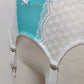 A white lace and Aqua blue Lycra, Mona garter belt with 6 adjustable straps and hook and eye closure, displayed on a mannequin. Detail