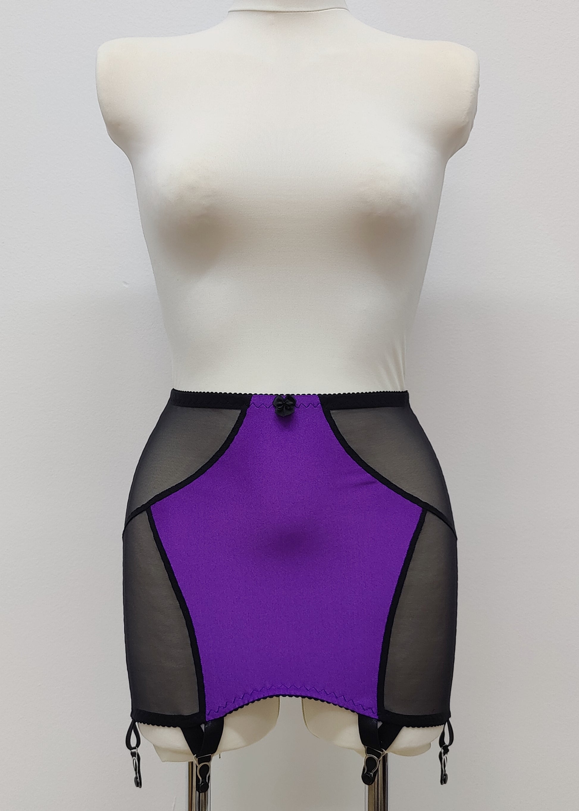 Open bottom Glenda girdle made with purple opaque front and back panels with black sheer mesh side panels. 
