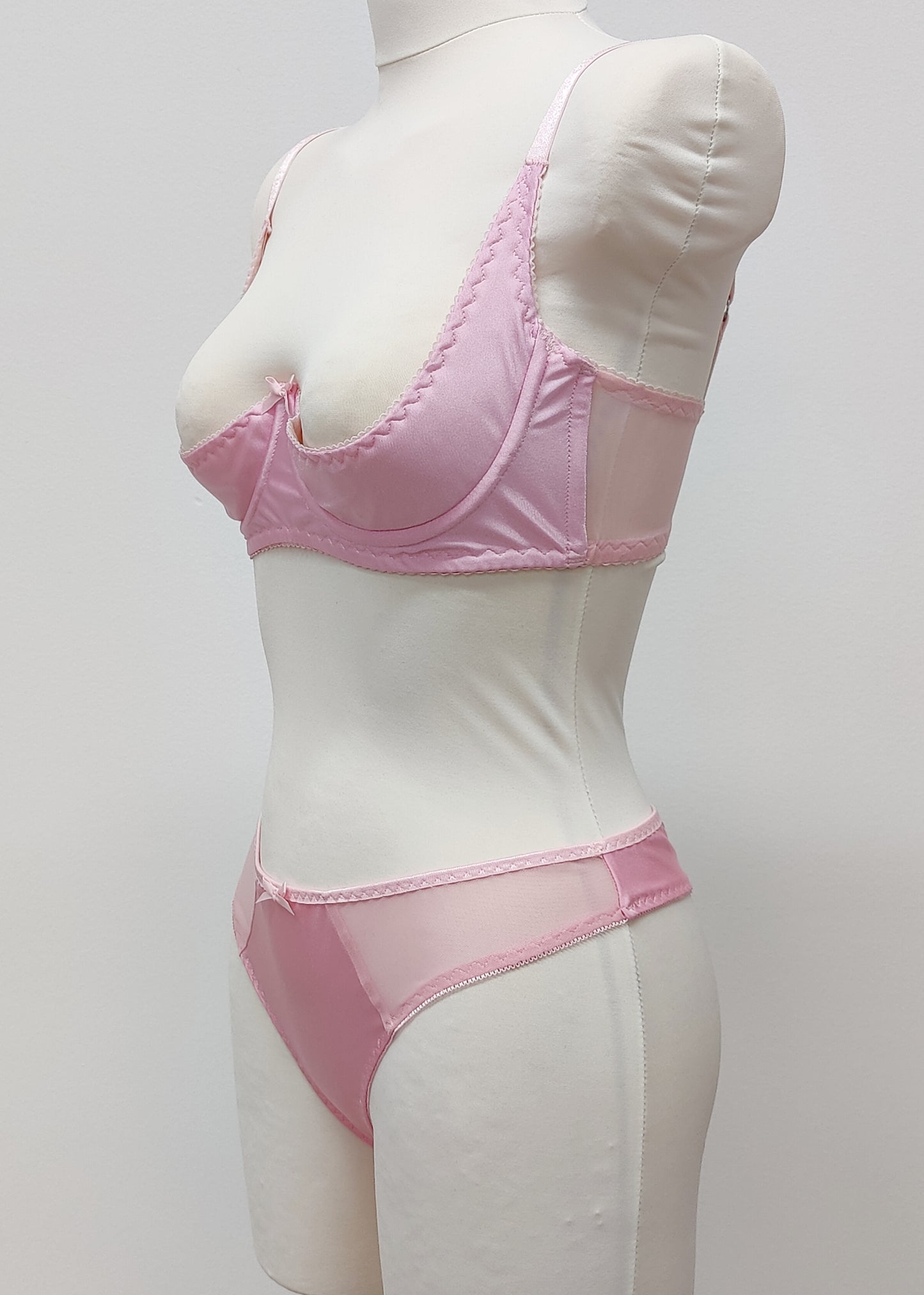 Mannequin wearing a  pink Gina quarter cup bra and Mia thong with sheer pink side panels 
