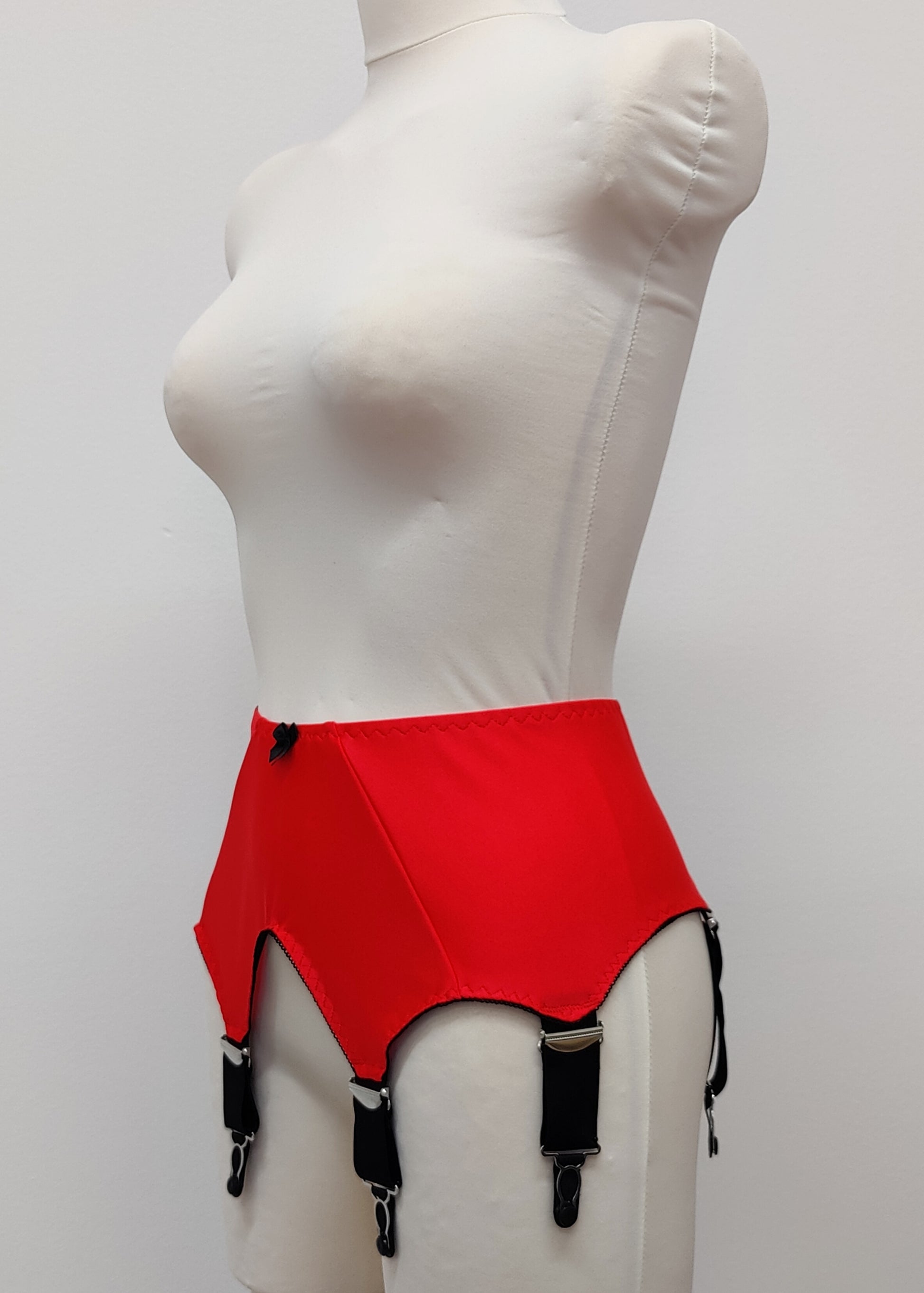wide vintage style Iris garter belt in colour Sunset Red, with black trim and 6 extra wide black straps, side view
