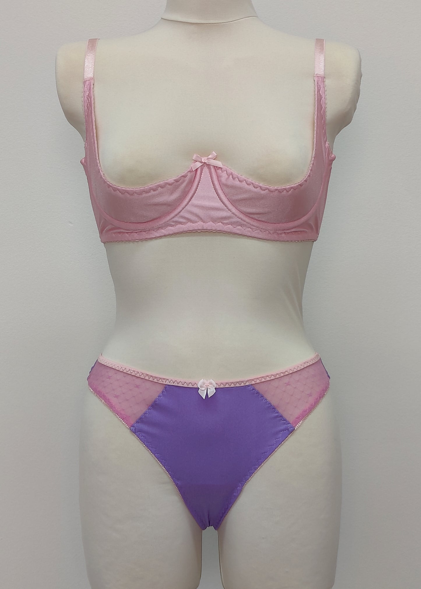 Mannequin wearing a  pink Gina quarter cup bra and  purple Mia thong with sheer pink side panels 
