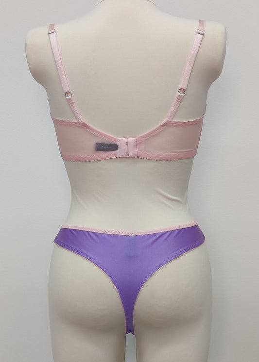 Mannequin wearing a pink Lucy bra and purple Mia thong underwear with pink sheer side panels , back view