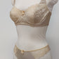 Beige lingerie set on a mannequin against a plain background. Zigi thong with side lace panels and Alice bra, side view
