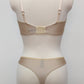 Beige lingerie set on a mannequin against a plain background. Zigi thong with side lace panels and Alice bra, back view