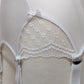 White lace garter belt on a mannequin against a neutral background, lace detail