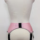 Pink high-waisted garter belt with extra wide black straps and bows