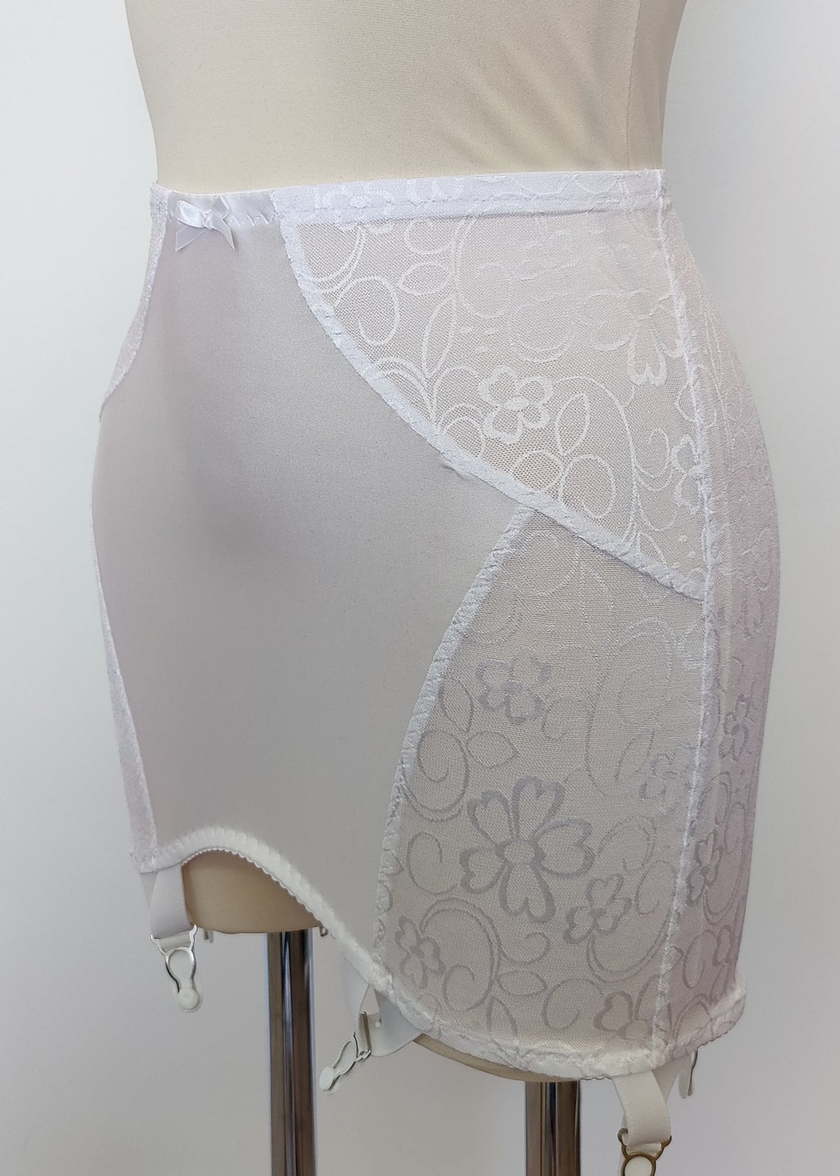white open bottom girdle with delicate shiny floral pattern, with 6 non adjustable v straps with cotton backed grips, detail
